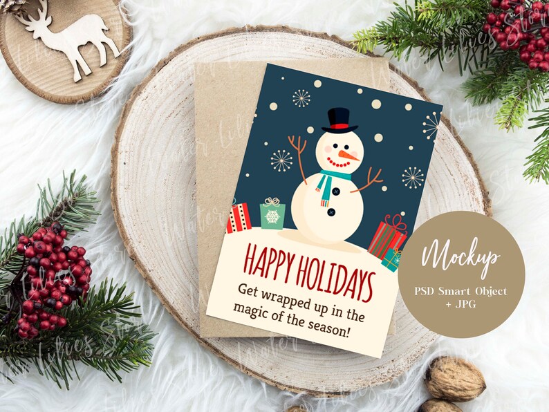 May include: A Christmas card mockup featuring a snowman with a blue scarf and hat, surrounded by presents. The card has a blue background with white snowflakes and the text "Happy Holidays Get wrapped up in the magic of the season!"