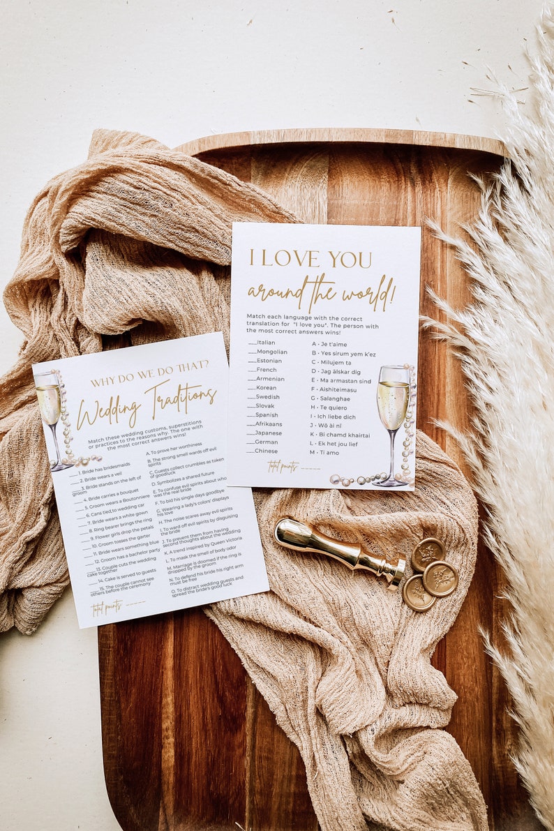 May include: Two printable game cards with gold accents. The first card is titled "Why Do We Do That? Wedding Traditions" and lists 15 wedding traditions with their meanings. The second card is titled "I Love You Around The World!" and lists 13 languages with their translations for "I love you".