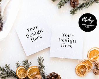 May include: Two white cards with the text "Your Design Here" on a white background with dried orange slices, pine branches, and pine cones.