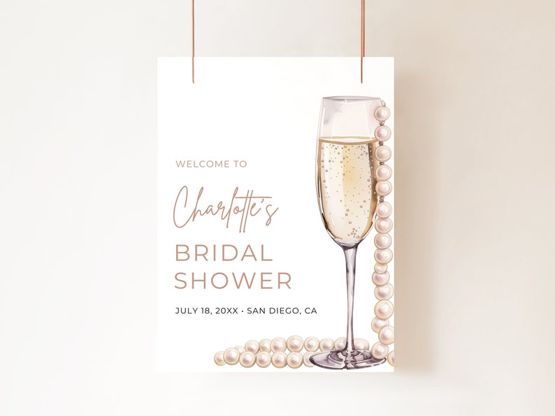 May include: A white bridal shower invitation with a champagne flute and pearls. The text reads "Welcome to Charlotte's Bridal Shower July 18, 20XX - San Diego, CA"