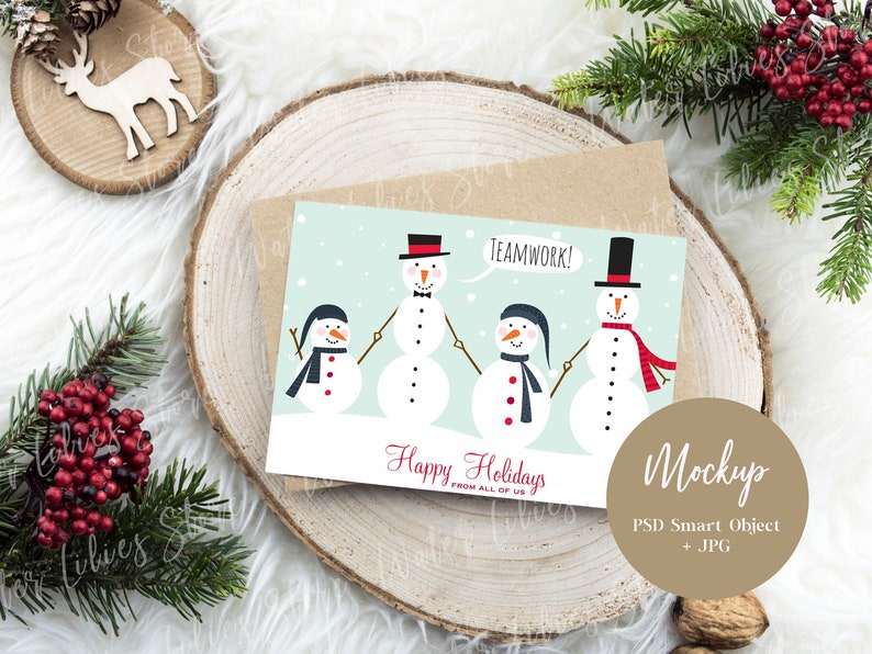 May include: A Christmas card with a light blue background featuring four snowmen holding hands. The snowmen are wearing hats, scarves, and buttons. The card says "Happy Holidays from all of us" and "Teamwork!" in red text.