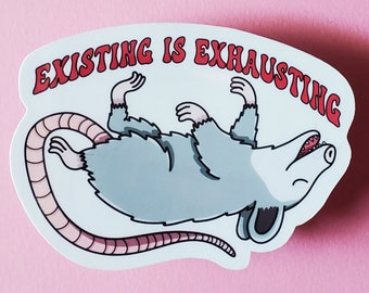 Op de afbeelding: Een witte sticker met een cartoon-opossum dat op zijn rug ligt met zijn mond open. De tekst "EXISTING IS EXHAUSTING" staat in rode letters boven het opossum.