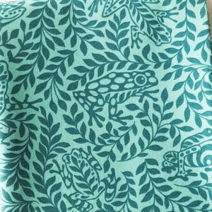 May include: Teal fabric with a repeating pattern of green frogs and leafy branches.