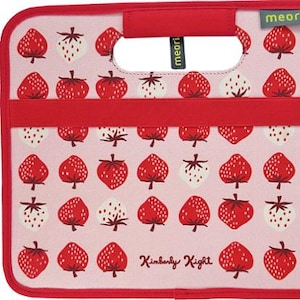 May include: A rectangular storage box with a pink background featuring a repeating pattern of red and white strawberries. The box has a red fabric handle, red trim, and the text meori and Kimberly Kight printed on the front surface.