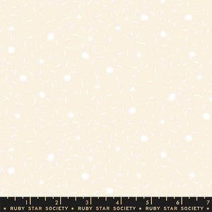 May include: Cream-colored fabric with a repeating pattern of white starbursts and dashes. The fabric has a soft, textured appearance, suitable for quilting or other craft projects. The bottom of the image has the text "RUBY STAR SOCIETY".