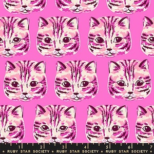 May include: A fabric pattern featuring a repeating print of cat faces in shades of pink, white, and dark purple against a bright pink background. A black measuring tape with the text Ruby Star Society is visible along the bottom edge of the image.