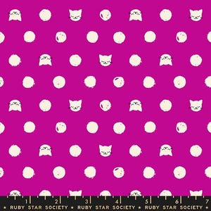 May include: A vibrant magenta fabric featuring a repeating pattern of off-white cat faces and textured circular dots. A black measuring tape with white markings and the text RUBY STAR SOCIETY is visible along the bottom edge of the fabric.