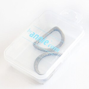 May include: A bronze-colored metal loop in a clear plastic case. The case has a blue logo that reads "byannie.com". The loop is a unique shape, possibly for a bag or craft project. The case is slightly angled.