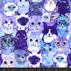 May include: A fabric print featuring a repeating pattern of cat faces in various shades of blue, purple, and white. The cats have diverse facial markings and expressions. A black ruler edge with the text Ruby Star Society is visible at the bottom.