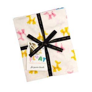 May include: A fat quarter bundle tied with a black ribbon. The fabric features a white backdrop adorned with pink and yellow balloon dog designs. A tag with the text "FLOAT" and "fat quarter bundle" is attached.