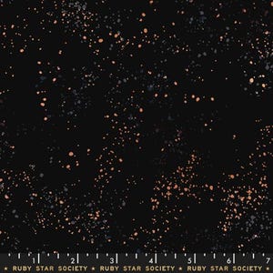 May include: A black fabric featuring a scattered pattern of small, irregular copper and dark gray paint-like splatters. A ruler at the bottom edge shows a scale of 7 inches, with the text "RUBY STAR SOCIETY" printed repeatedly along the margin.