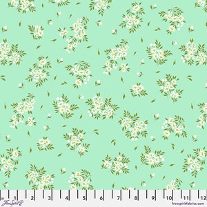 May include: A mint green fabric with a repeating pattern of white floral sprigs. The fabric is 12 inches wide and has a ruler marked in inches along the bottom.