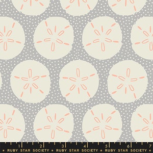 May include: A gray fabric with a white and pink repeating pattern of sand dollars. The fabric has a subtle white polka dot pattern.