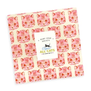 May include: A stack of fabric squares featuring a repeating pattern of pink and orange cat faces on a cream background. A white label on top reads: RUBY STAR SOCIETY, Oops! ALL CATS, BY SARAH WATTS, with a black cat silhouette and small paw prints.