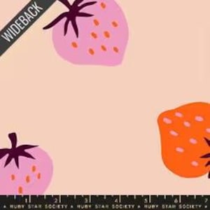 May include: Wideback fabric with a repeating pattern of large, stylized strawberries in pink and orange on a light peach background. The fabric has a ruler graphic along the bottom edge and the text "WIDEBACK" in the upper left corner.