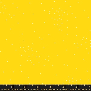 May include: A bright yellow fabric with a white polka dot pattern. The fabric has a ruler printed at the bottom with the text "Ruby Star Society" repeated.
