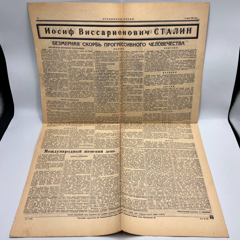 May include: An open vintage newspaper with text in a foreign language. The headline reads "Iosif Vissarionovich Stalin" and "Bezmernaia Skorb Progressivnogo Chelovechestva". The newspaper is yellowed with age and has multiple pages of text.