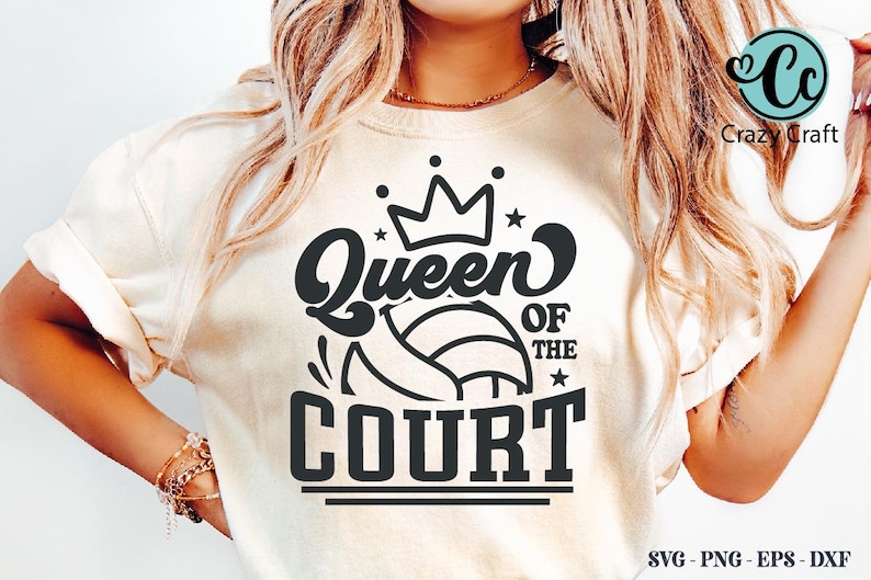 K&ouml;nnte beinhalten: Cremefarbenes T-Shirt mit einem schwarzen Aufdruck, der "Queen of the Court" &uuml;ber einem Volleyball-Design zeigt. Der Text ist mit einer Krone und Sternen gestaltet. Das T-Shirt ist ein Freizeitkleidungsst&uuml;ck.