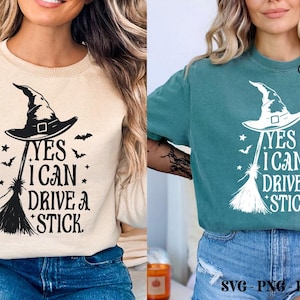 K&ouml;nnte beinhalten: Beiges Sweatshirt und t&uuml;rkisfarbenes T-Shirt mit Hexenhut, Besen und dem Text "YES I CAN DRIVE A STICK" in Schwarz und Wei&szlig;. Das Design beinhaltet Flederm&auml;use und Sterne, perfekt f&uuml;r Halloween.