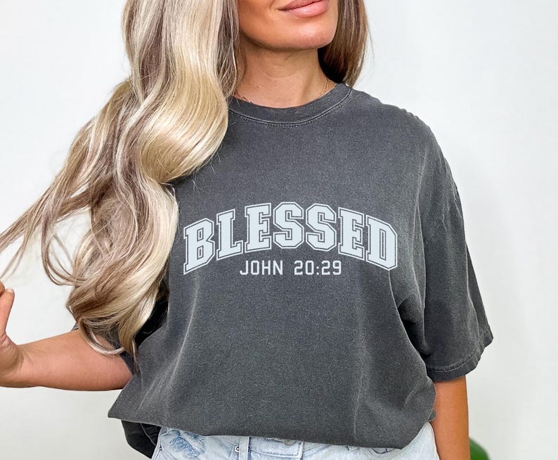 K&ouml;nnte beinhalten: Ein anthrazitfarbenes T-Shirt mit einer wei&szlig;en Grafik, auf der "Blessed John 20:29" steht.