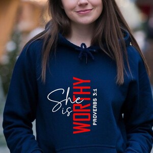 May include: A navy blue hoodie with a white and red graphic that says "She is Worthy" and "Proverbs 3:1".