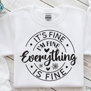 Pu&ograve; includere: Felpa bianca girocollo con la scritta nera "IT'S FINE I'M FINE Everything IS FINE" in un design circolare. Il design include cuori e fiori. La felpa ha uno stile casual.