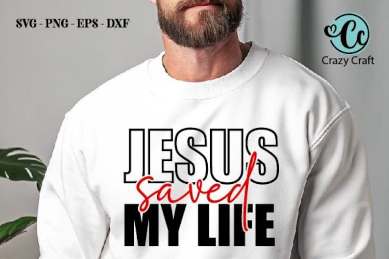 以下が含まれることがあります： 「JESUS saved MY LIFE」の文字が黒と赤でプリントされた白いスウェットシャツ。「JESUS」と「MY LIFE」は太字のブロック体、「saved」は筆記体です。Crazy Craftのロゴも表示されています。