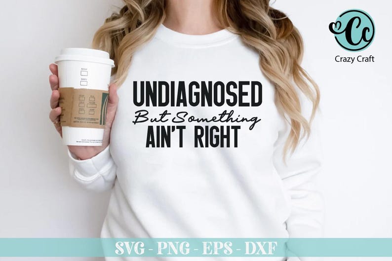 May include: White long-sleeve shirt with black text that reads "UNDIAGNOSED But Something AIN'T RIGHT".