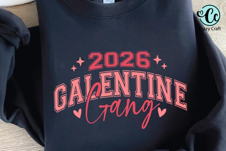 May include: Navy blue sweatshirt with a red and pink graphic. The graphic reads "2026 Galentine Gang" with star and heart accents. The Crazy Craft logo is in the upper right corner.