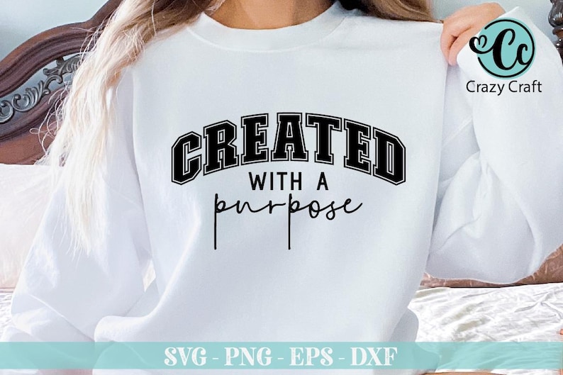 K&ouml;nnte beinhalten: Wei&szlig;er Pullover mit schwarzem Text, der "CREATED WITH A purpose" lautet.