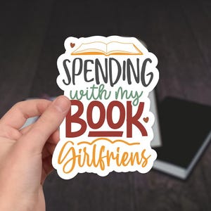 May include: White sticker with a book illustration and the text "Spending with my Book Girlfriends".