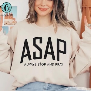 May include: Beige sweatshirt with the text "ASAP" in large black letters, with "ALWAYS STOP AND PRAY" underneath. The sweatshirt is a neutral color and has long sleeves. The Crazy Craft logo is visible in the upper left corner.