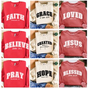 K&ouml;nnte beinhalten: Neun verschiedene Sweatshirts mit verschiedenen religi&ouml;sen Botschaften bedruckt. Die Sweatshirts sind in den Farben Rot, Creme und Koralle. Die Botschaften lauten "Glaube", "Gnade", "Geliebt", "Glaube", "Erstellt mit einem Zweck", "Jesus liebt mich", "Bete", "Hoffnung" und "Gesegnet".