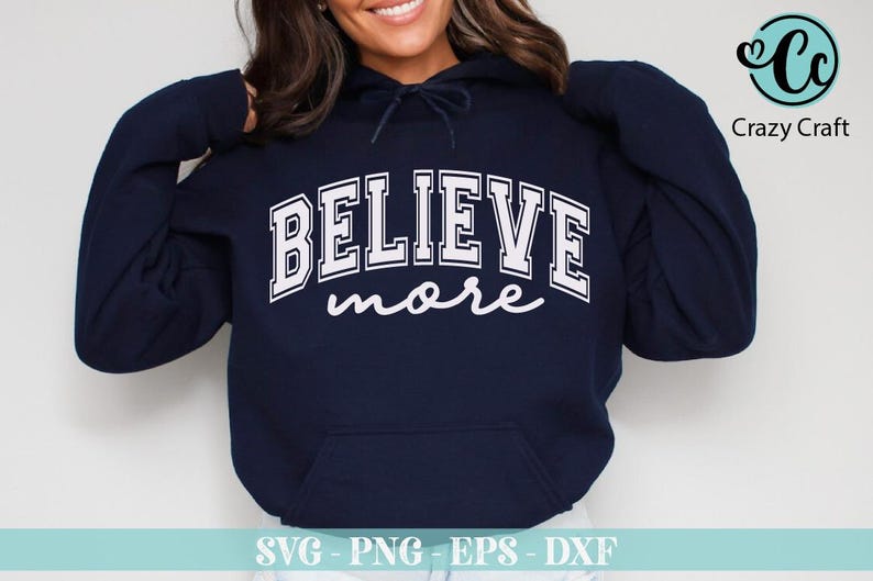 May include: Navy blue hoodie with the words "BELIEVE more" in white block letters. The word "BELIEVE" is arched across the chest, and "more" is written in a cursive font below. The hoodie has a front pocket and a drawstring hood.