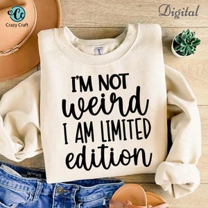 May include: A white sweatshirt with black text that reads "I'm not weird I am limited edition".