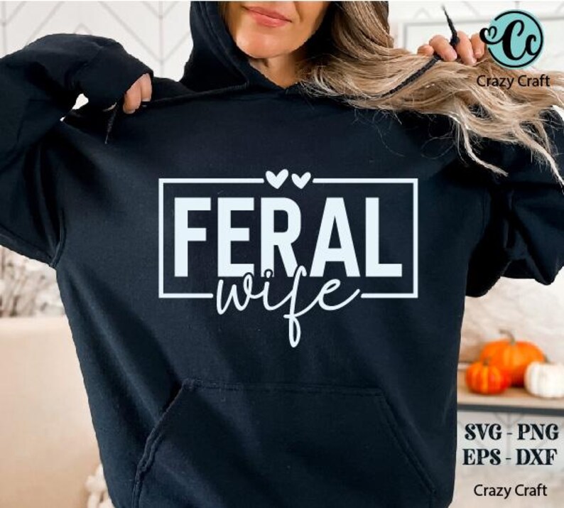 May include: A black hoodie with a white graphic that says "Feral wife" in a rectangle with two small hearts above it.