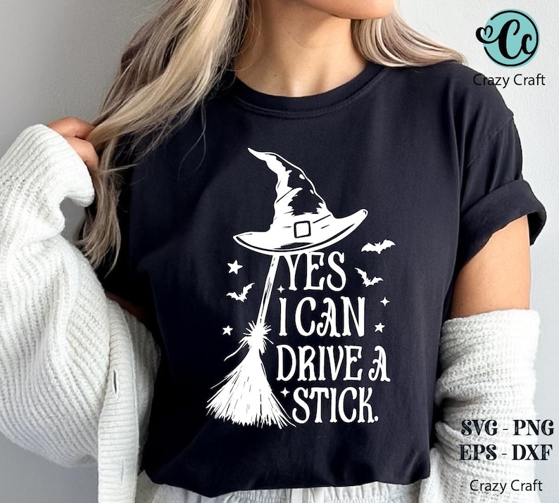 K&ouml;nnte beinhalten: Schwarzes T-Shirt mit wei&szlig;er Grafik, die einen Hexenhut, einen Besen, Flederm&auml;use und Sterne zeigt. Der Text lautet "YES I CAN DRIVE A STICK." Das Design umfasst SVG-, PNG-, EPS- und DXF-Dateiformate.