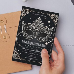 May include: A black rectangular invitation card featuring a silver masquerade mask graphic with pearl accents, ornate corner flourishes, and white text that reads: PLEASE JOIN US FOR A MASQUERADE PARTY, Marcus's 35th Birthday, SATURDAY, DECEMBER 25, AT 10:00PM.