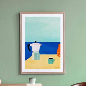 Könnte beinhalten: Gerahmter Kunstdruck mit einer Kaffee-Szene. Dargestellt sind ein weißer Espressokocher, eine türkisfarbene Tasse und eine orangefarbene Flasche auf einer gelben Oberfläche, mit blauem Meer und Himmel im Hintergrund. Der Druck ist in einem Holzrahmen.