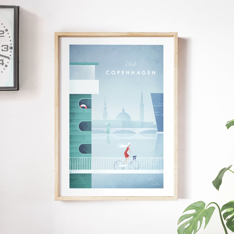 May include: A minimalist poster with a blue background and a woman riding a bicycle on a bridge. The poster says "Visit Copenhagen" in white text.