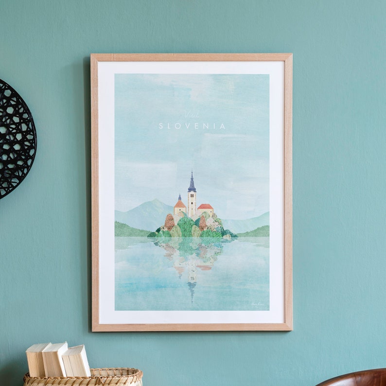 K&ouml;nnte beinhalten: Ein Aquarellbild einer Kirche auf einer Insel in einem See. Die Kirche hat ein rotes Dach und einen blauen Kirchturm. Der See ist von Bergen umgeben. Der Text "Besuchen Sie Slowenien" befindet sich oben auf dem Bild.