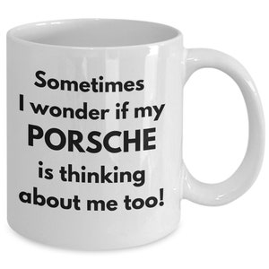 May include: White ceramic coffee mug with black text that reads "Sometimes I wonder if my PORSCHE is thinking about me too!"