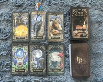 May include: Tarot Familiars deck by LP Barker. The cards feature black cats, a deer, a wolf, and other creatures. The box is black with gold lettering.