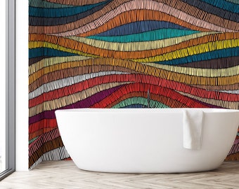 May include: A white bathtub sits in front of a wall with a colorful abstract pattern. The pattern is made up of wavy lines of different colors, including red, orange, yellow, green, blue, and purple. The wall is in a bathroom with a wooden shelf unit to the right.