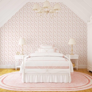 May include: A white metal bed frame with a white and pink bedding set. The bed is in a room with pink floral wallpaper and a white rug.