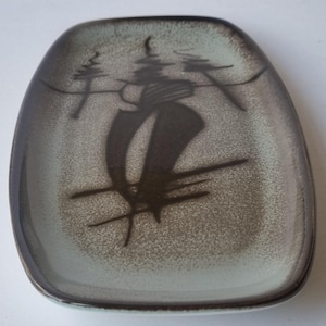 May include: A rectangular ceramic tray with rounded corners, featuring a light grey base with a dark brown gradient rim. The centre displays a dark brown abstract hand-painted design of three stylised trees against a textured background.