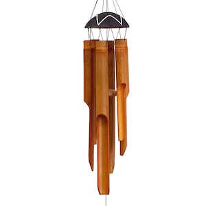May include: A brown bamboo wind chime with a black and white top. The chime has six tubes of varying lengths.