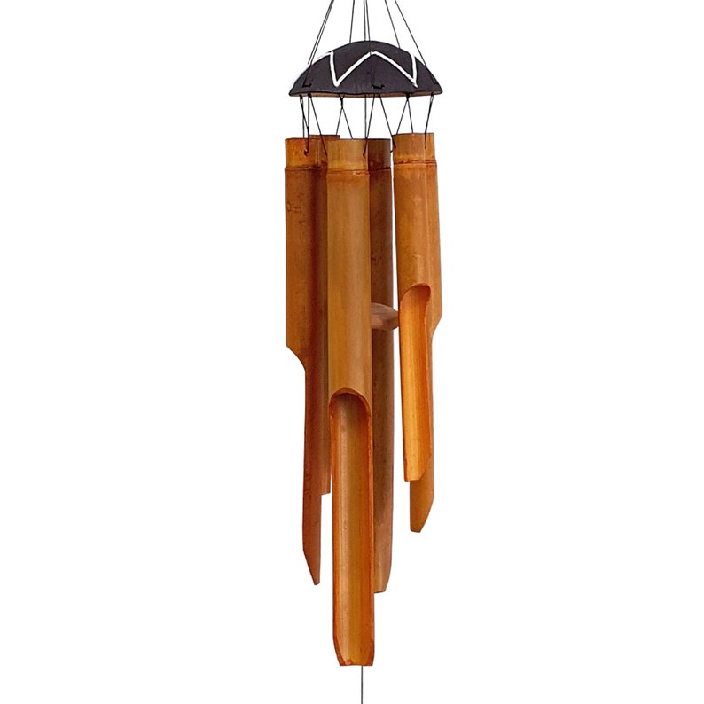 May include: A brown bamboo wind chime with a black and white top. The chime has six tubes of varying lengths.
