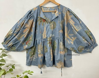 May include: A blue cotton blouse with a floral print featuring trees and plants. The blouse has a V-neckline, long sleeves, and a drawstring at the bottom. The text "ARKFashionhub" is visible in the bottom right corner of the image.
