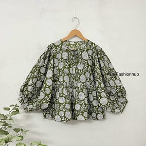 May include: A green and white floral print blouse with a gathered neckline and puffed sleeves.